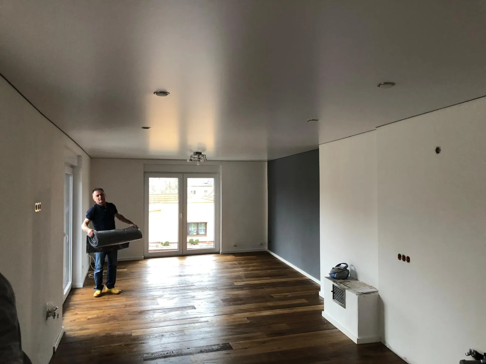 Fertiger Raum mit neuer Decke, die Schutzmatten werden aufgerollt