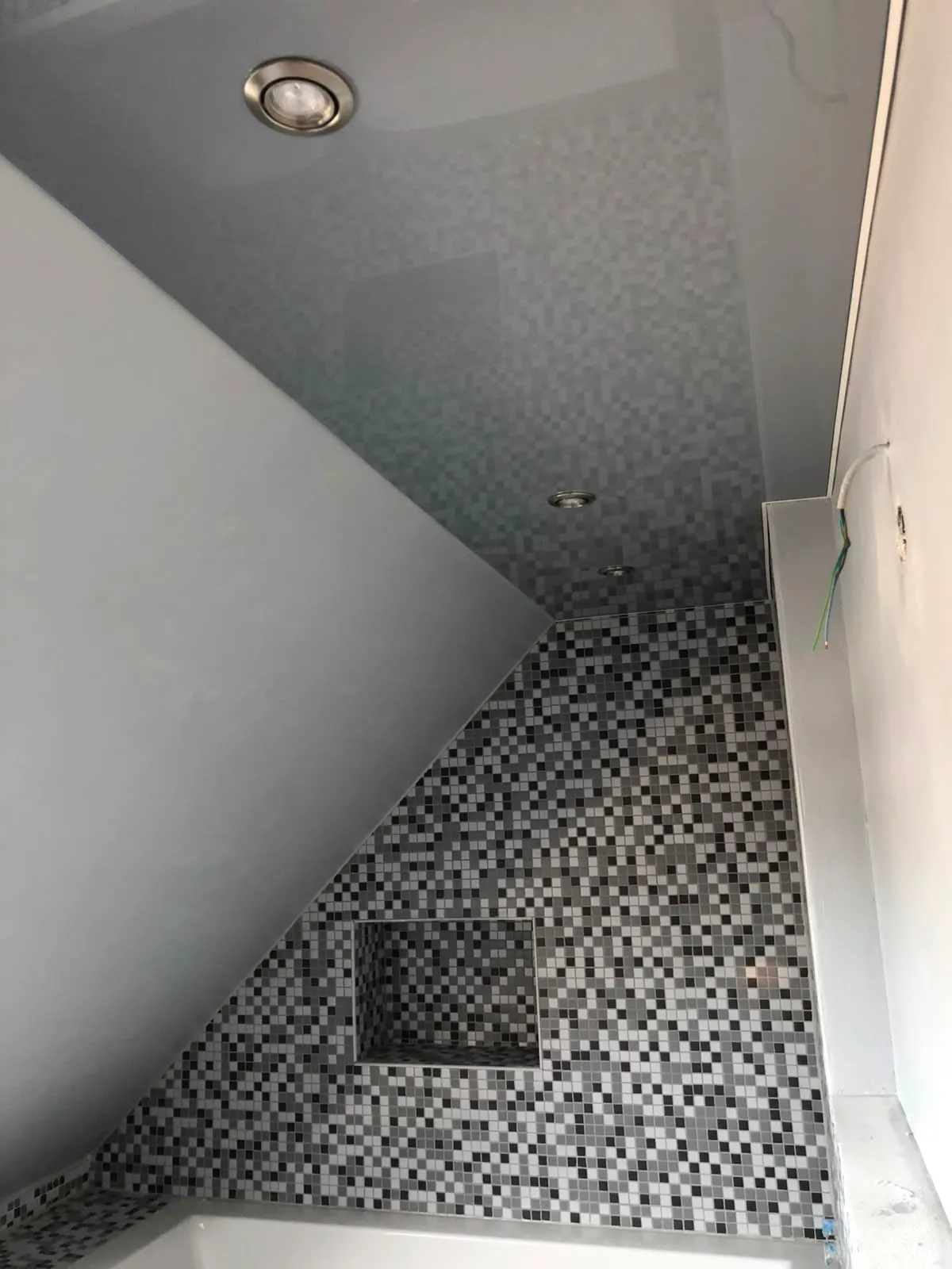 Graue Lackdecke, sauber an eine Dachschräge mit Mosaikfliesen angearbeitet