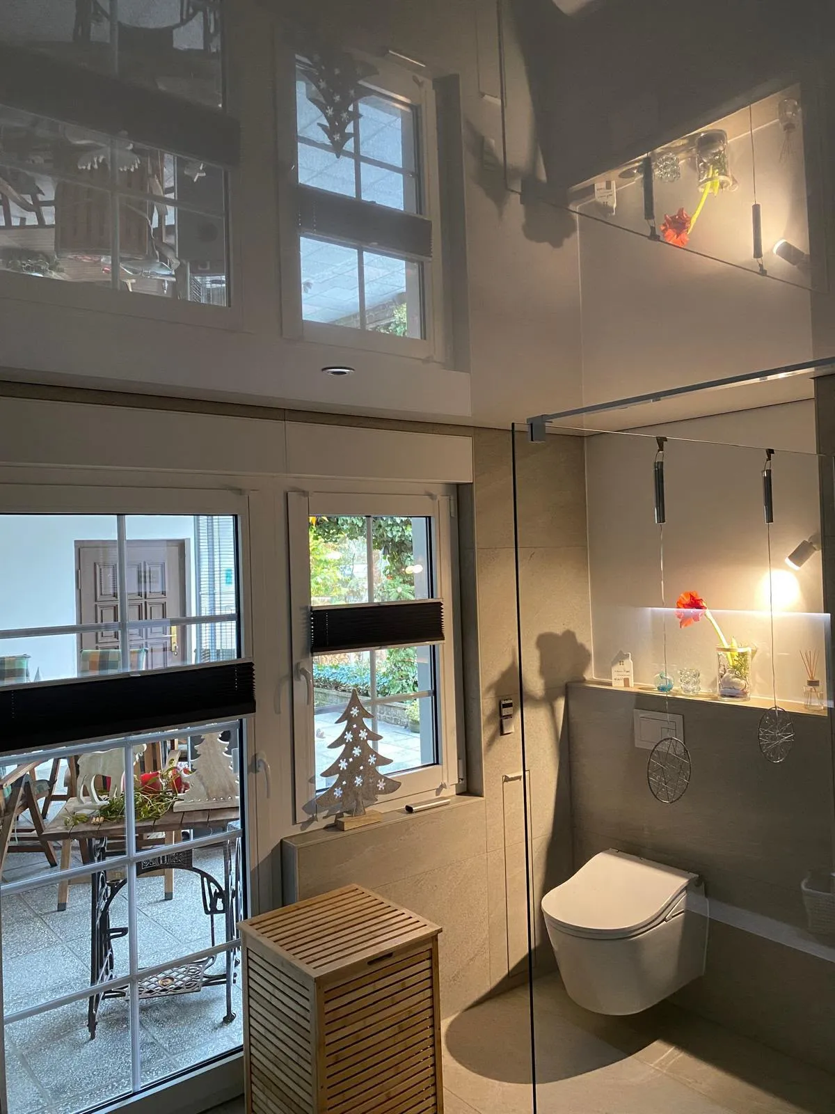 Dunkle Hochglanzdecke über Bad und Dusche, Fenster und Raum spiegeln sich darin