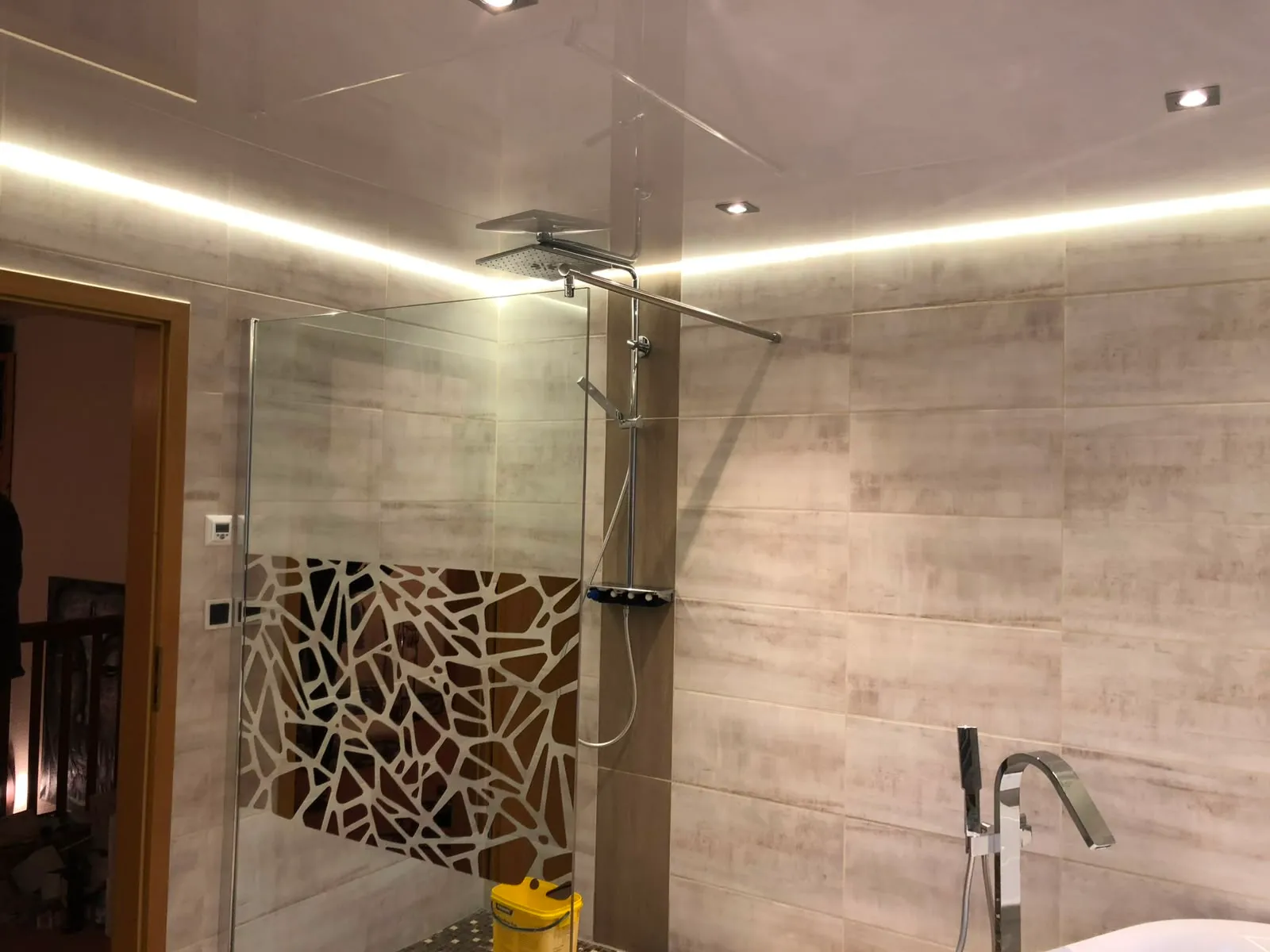 Walk-in-Dusche unter einer Lackdecke mit warmer Lichtvoute