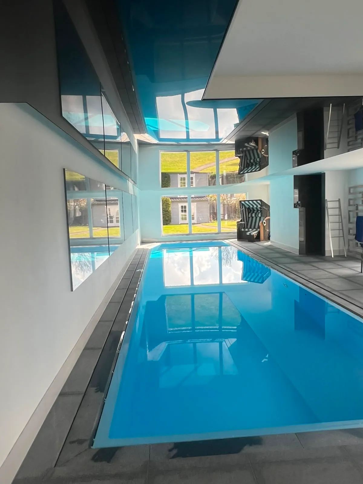 Schwarze Lackdecke über einem privaten Schwimmbad, spiegelt das Wasser