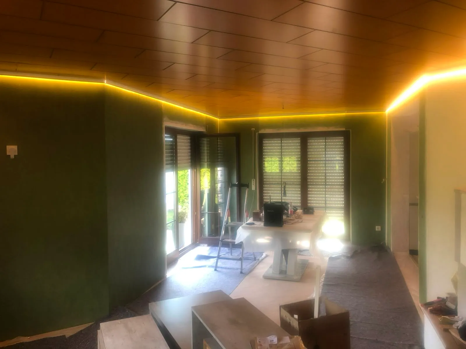 Wohnraum mit Holzdecke und warmer, umlaufender LED-Voute