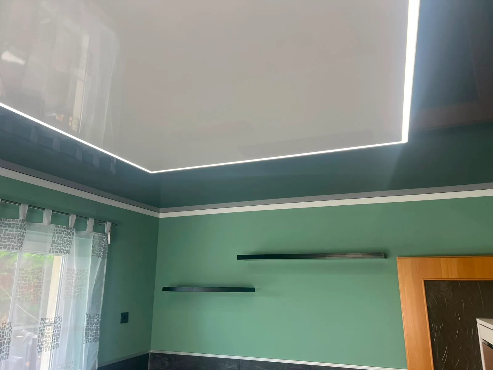 Lichtpanel mit LED-Linie über einer Küche mit grünen Wänden