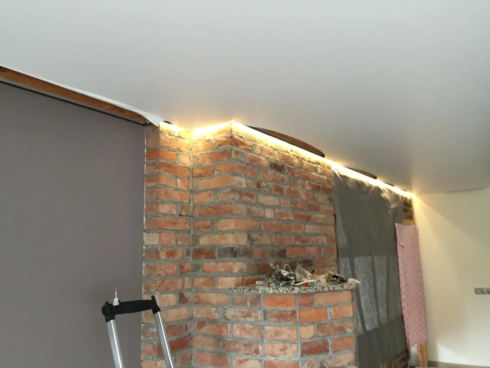 Warmes LED-Band in der umlaufenden Lichtvoute über der Ziegelwand